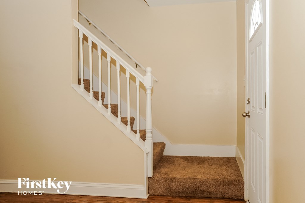 a stairway in a home with a carpeted stairwell and a white door