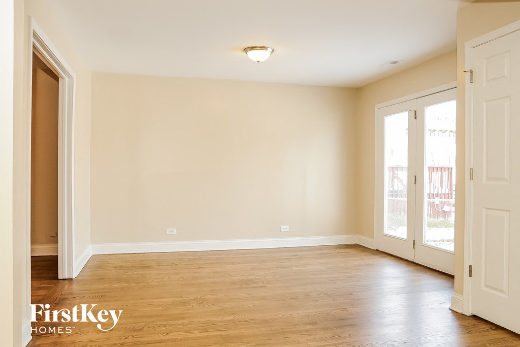 an empty living room with wood floors and white walls