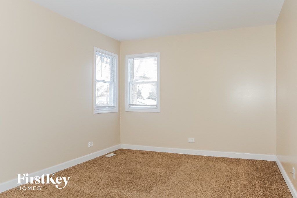 a empty room with two windows and a carpet