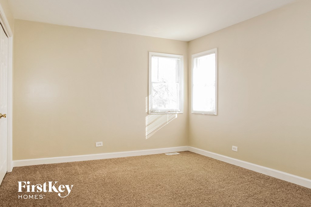a empty room with two windows and a carpet