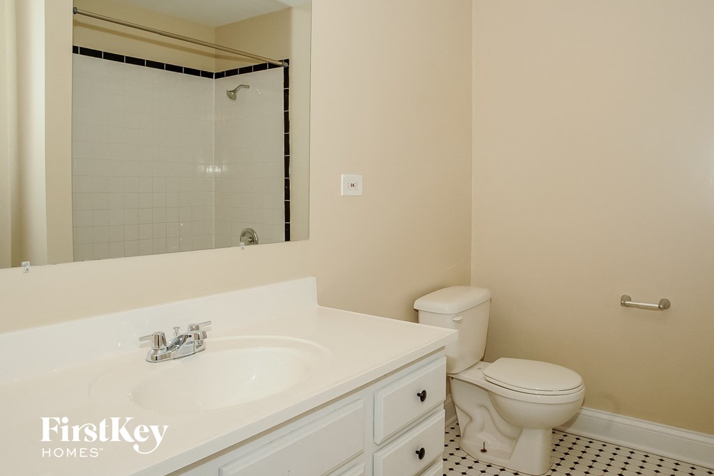 a bathroom with a sink toilet and a mirror