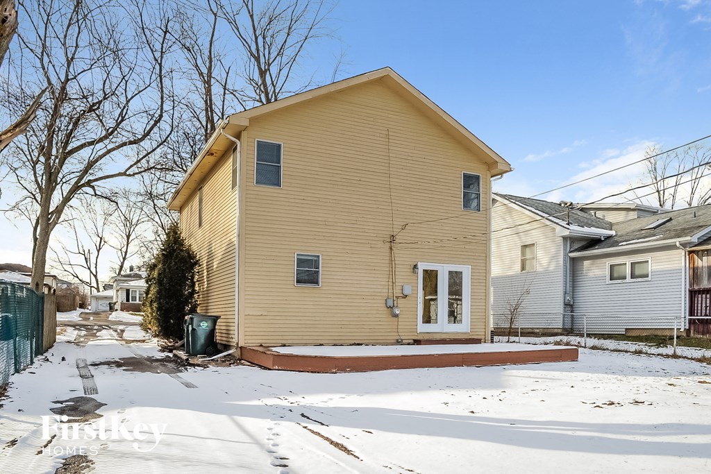 a yellow house with a yard in the snow
