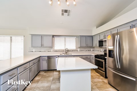 A modern kitchen with a stainless steel refrigerator and a central island.