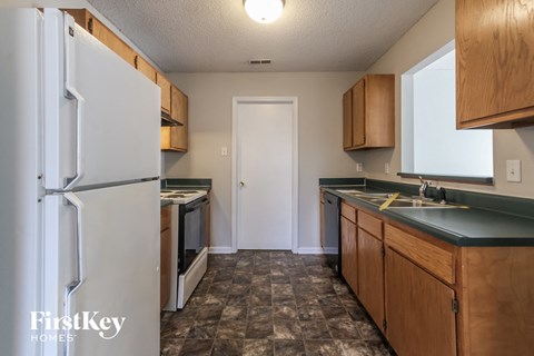 a kitchen with white appliances and wooden cabinets and a refrigerator