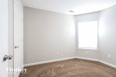 a bedroom with a carpeted floor and a window