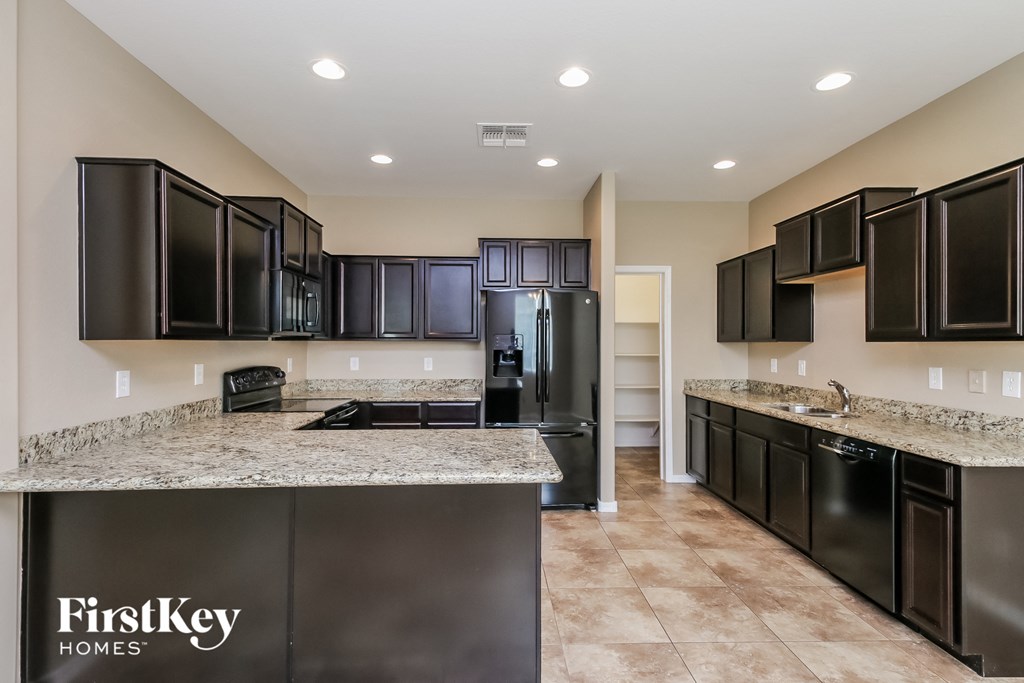 a kitchen with granite counter tops and black appliances