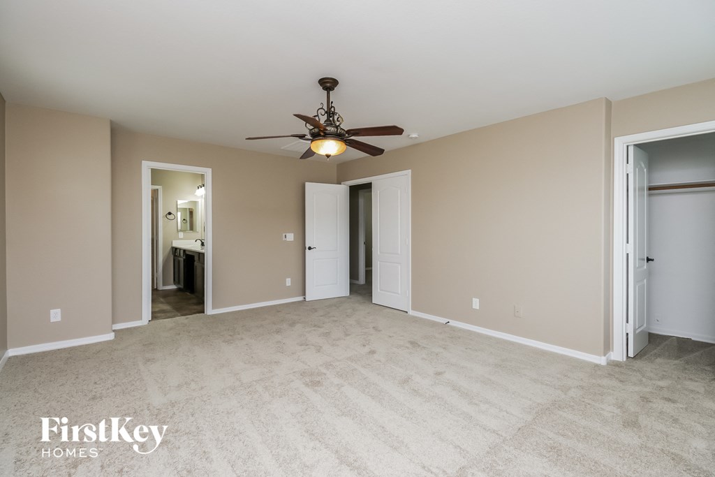 an empty living room with a ceiling fan