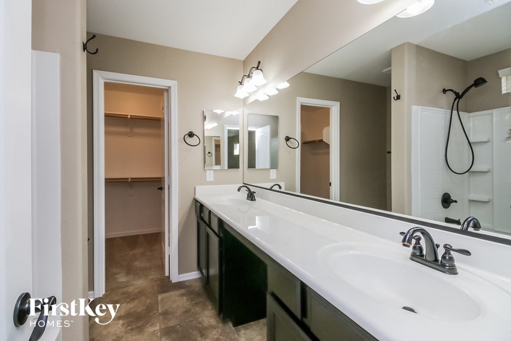 the master bathroom has a large vanity and a walk in shower