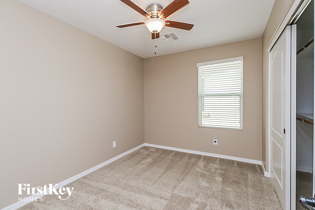 an empty room with a ceiling fan and a closet