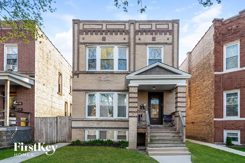 the front of a brick house with stairs and a porch
