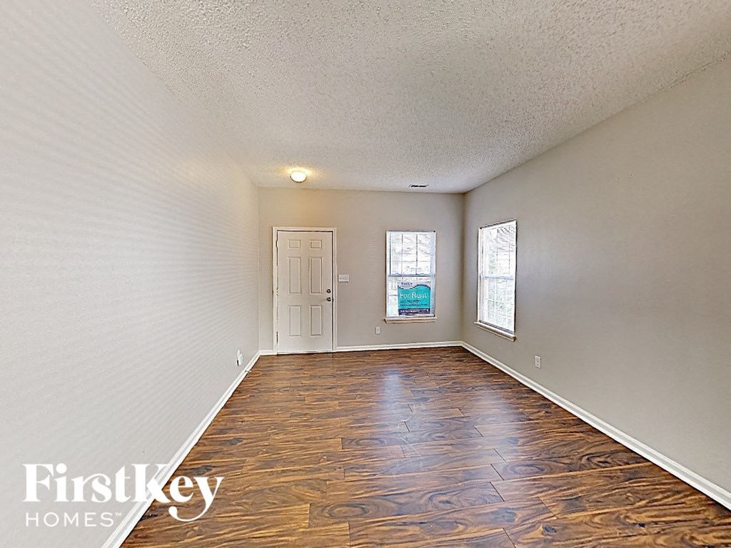 A room with wooden flooring and a white door.