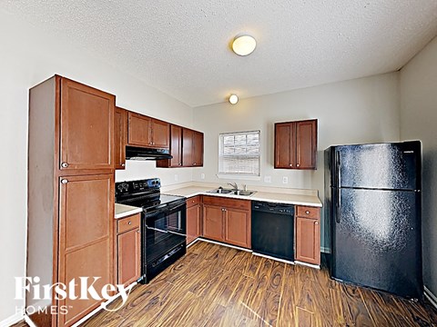 A kitchen with wooden cabinets and black appliances.