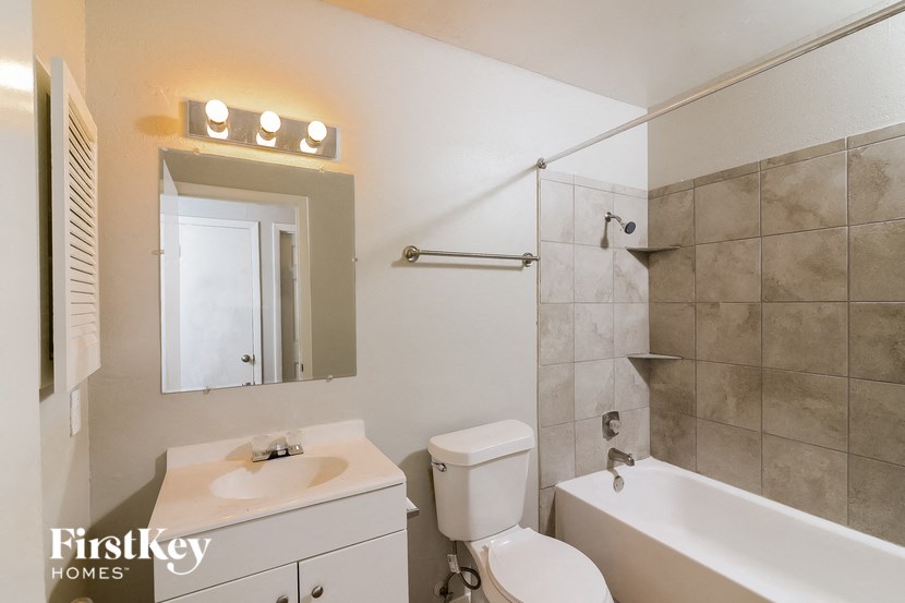 a bathroom with a sink toilet and a mirror