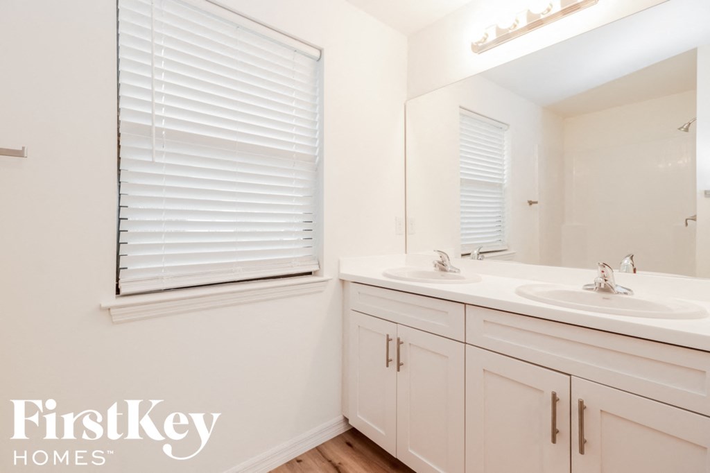 a bathroom with two sinks and a large mirror
