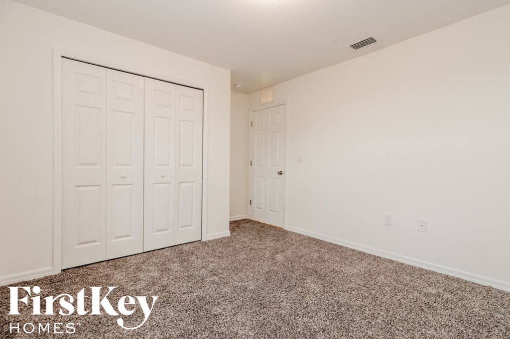 a bedroom with two closets and a carpeted floor
