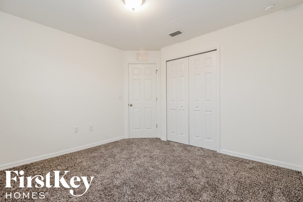a bedroom with two closets and a carpeted floor