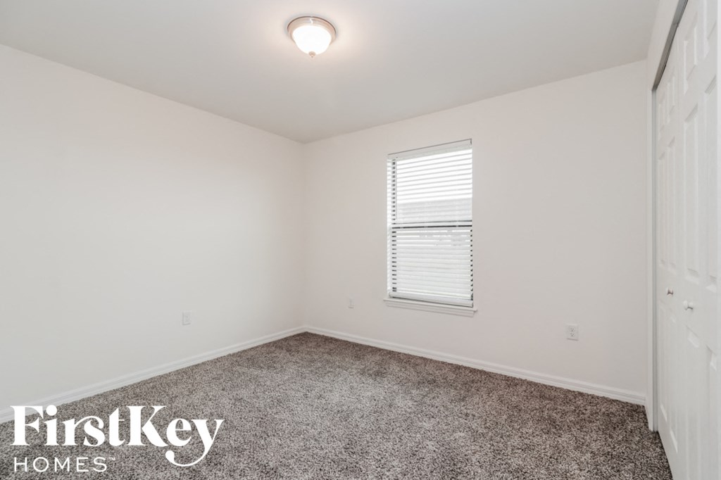 a bedroom with a carpeted floor and a window