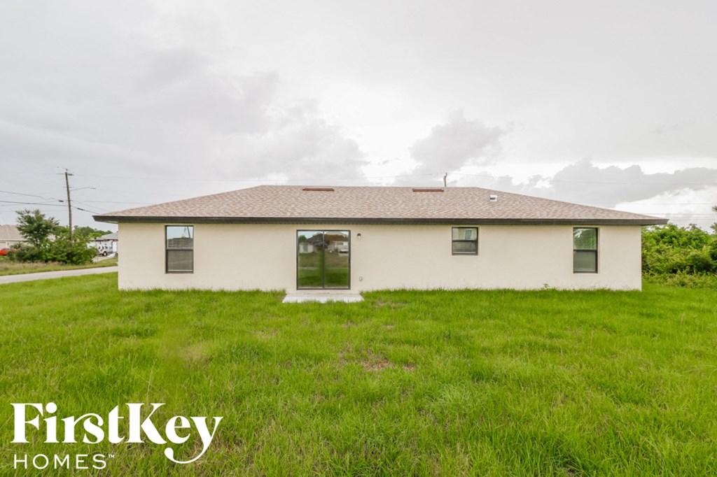 the front of a white house in a field