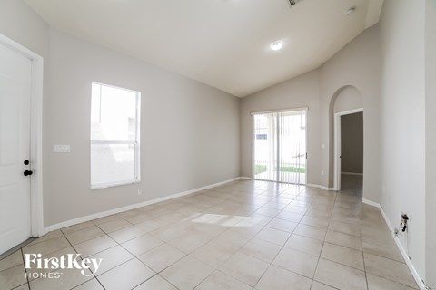 an empty living room with tiled floors and a door to a patio