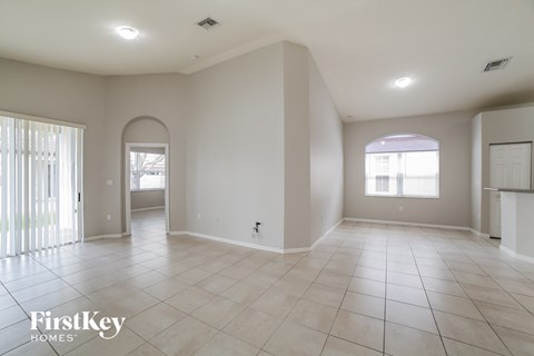 an empty living room with tiled floors and white walls