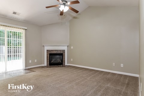 the living room with fireplace and ceiling fan