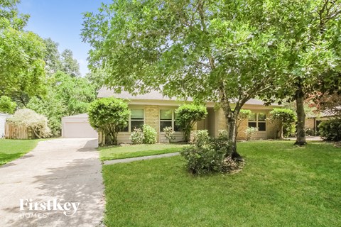 A house with a lawn and trees in front of it.
