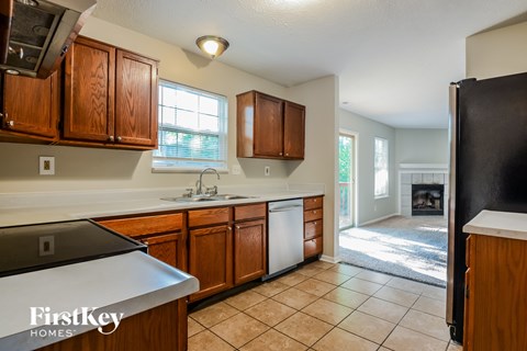 A kitchen with wooden cabinets and a black refrigerator.
