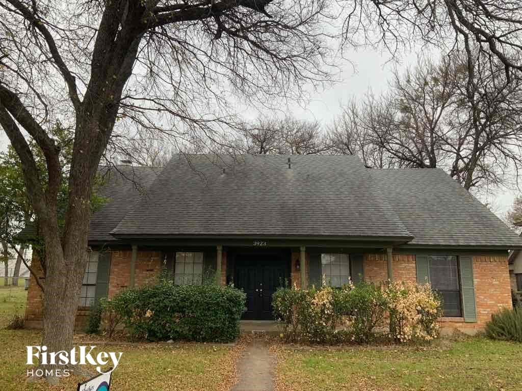 A brick house with a black door and a sign that says FirstKey Homes.
