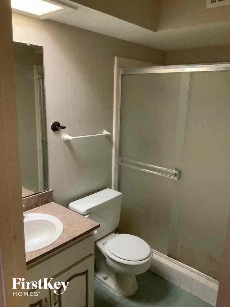 A bathroom with a toilet, sink, and shower.