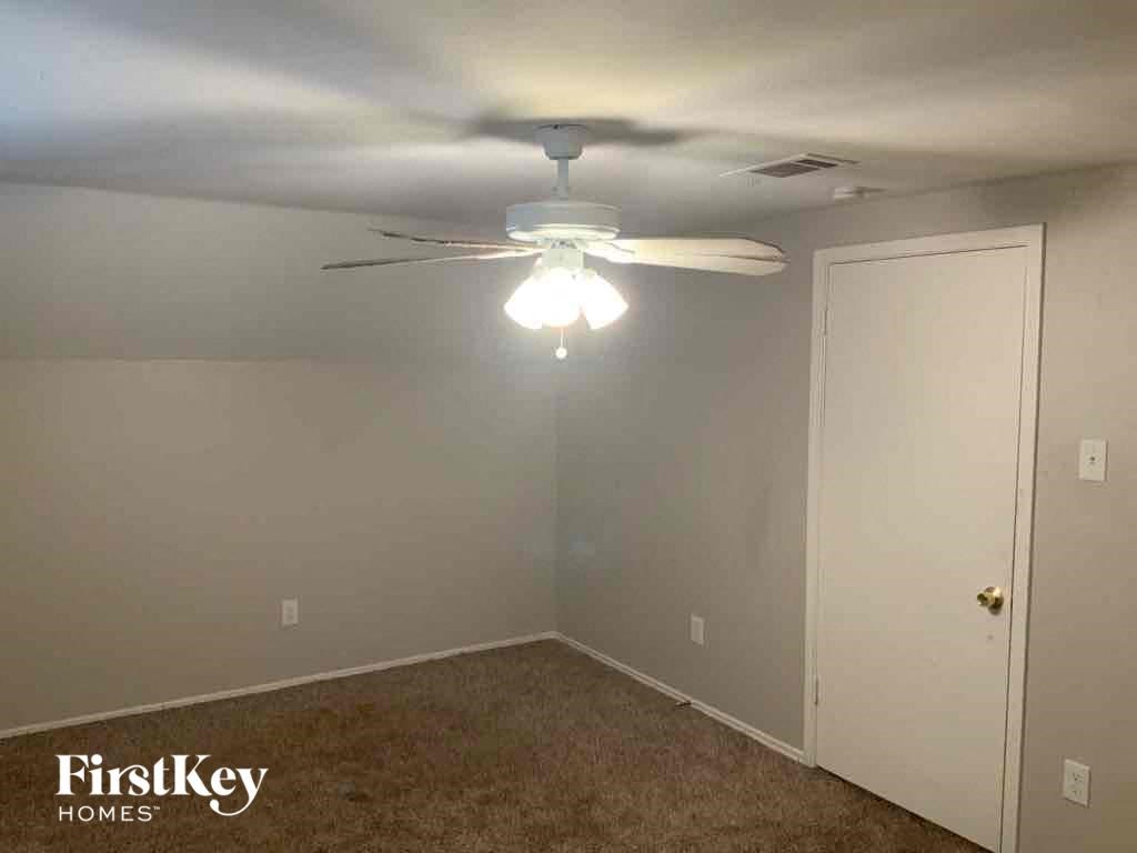 A room with a ceiling fan and a light fixture.