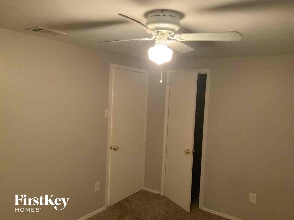 A room with a ceiling fan and two doors.