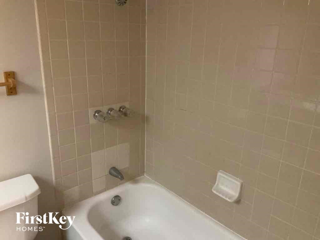 A white bathtub in a bathroom with a FirstKey Homes logo.