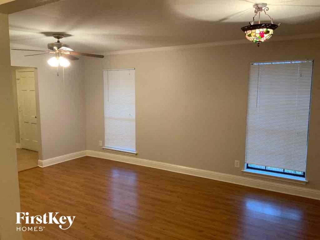 A room with wooden floors and a ceiling fan.
