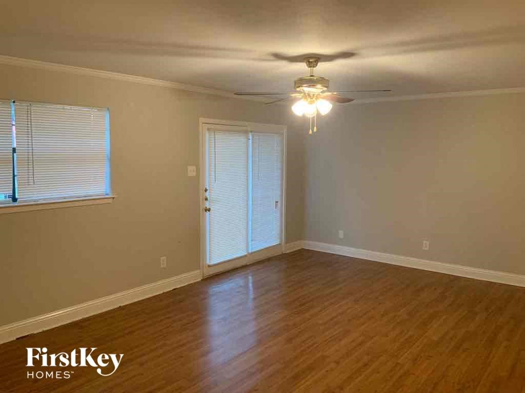 A room with wooden floors and a ceiling fan.