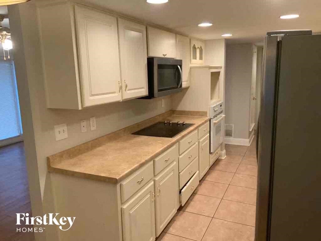 A kitchen with white cabinets and a beige countertop.