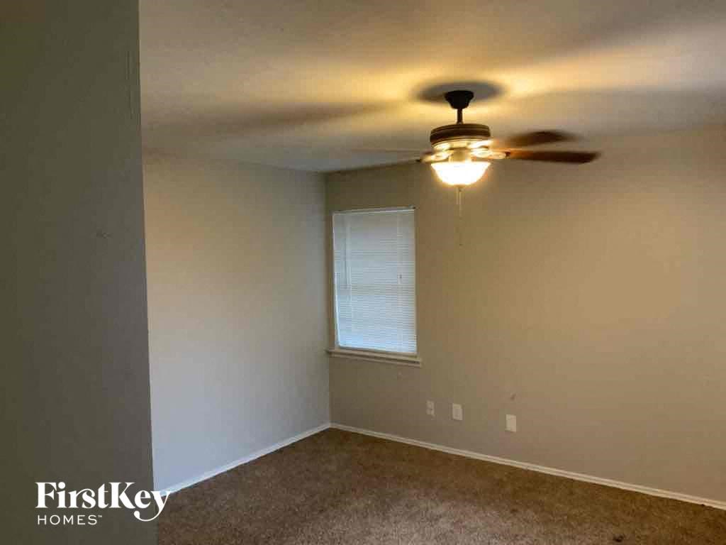 A room with a ceiling fan and a window.