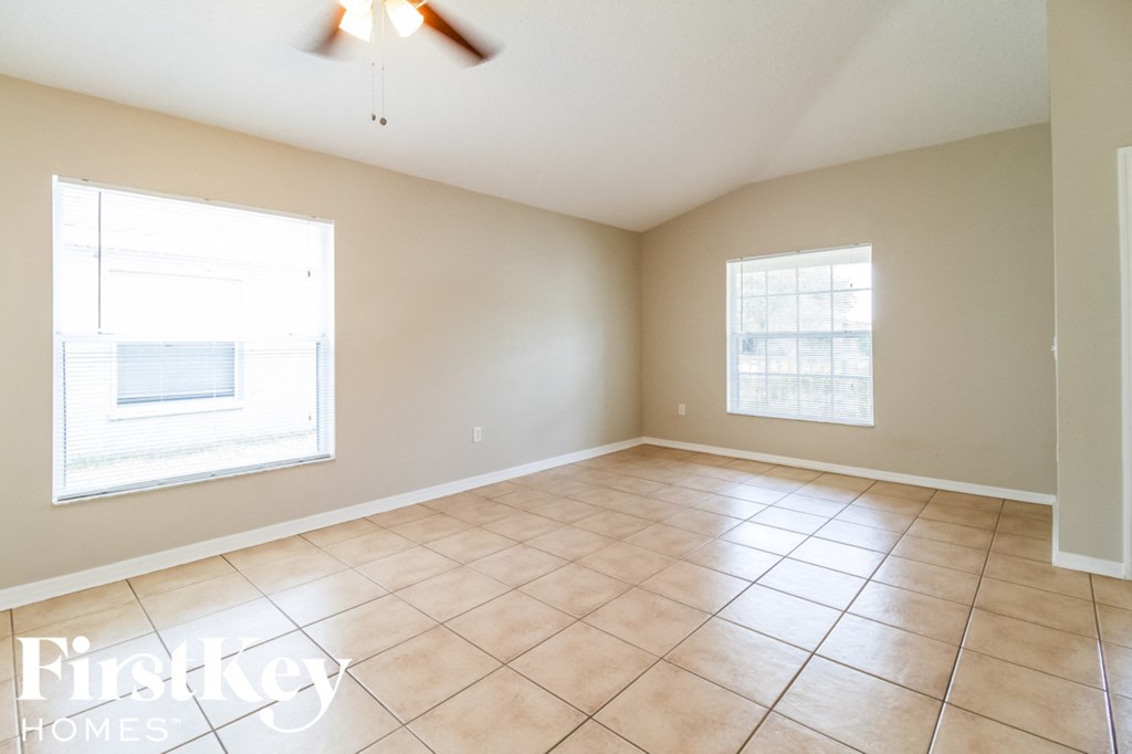 A room with a tiled floor and two windows.