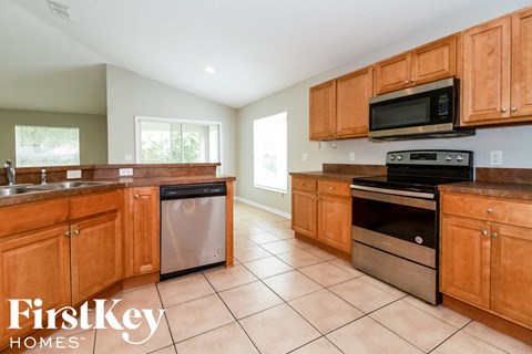 A kitchen with wooden cabinets and a stainless steel dishwasher.