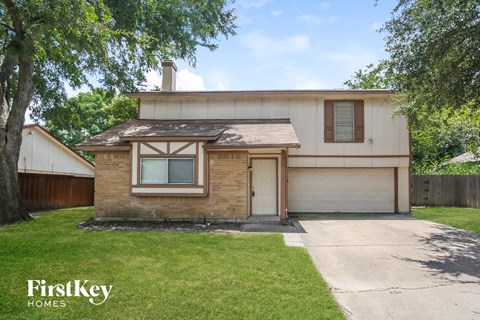 a brick house with a garage and a lawn