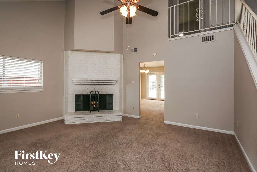 a living room with a fireplace and a ceiling fan