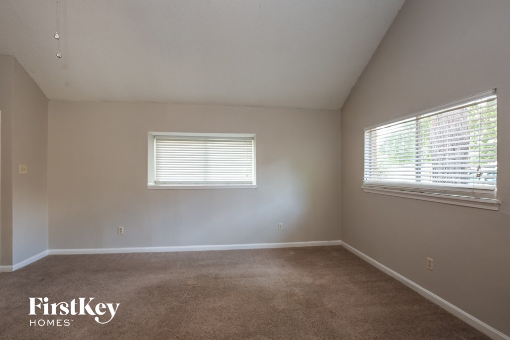 a bedroom with a carpeted floor and two windows