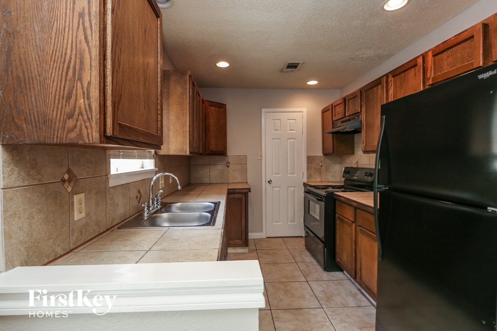 a kitchen with black appliances and wooden cabinets