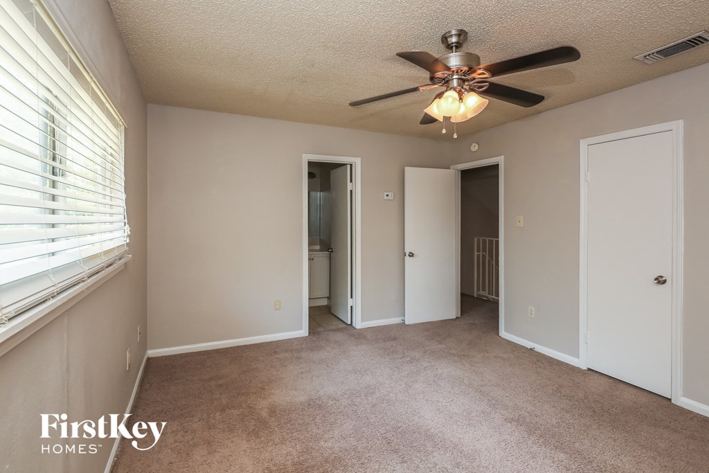 a living room with a ceiling fan and a large window