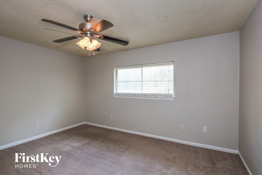 a bedroom with a ceiling fan and a window