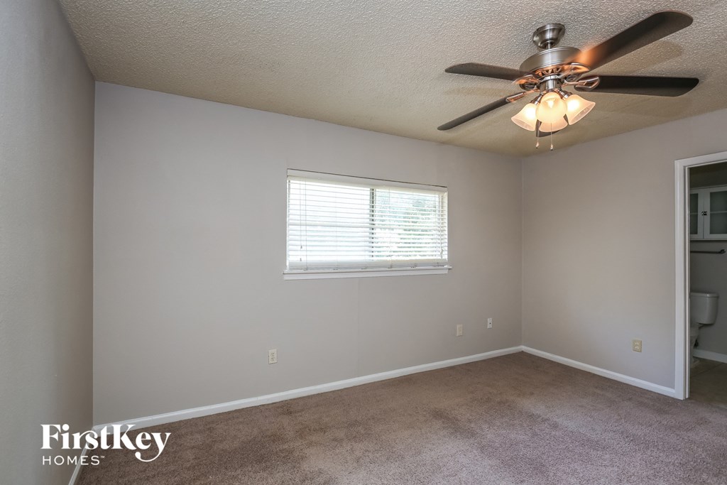 a bedroom with a ceiling fan and a window