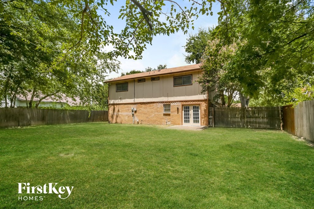 an old brick house in a backyard with grass and trees