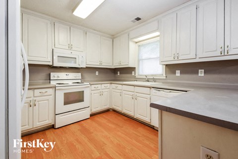 a kitchen with white cabinets and a wood floor