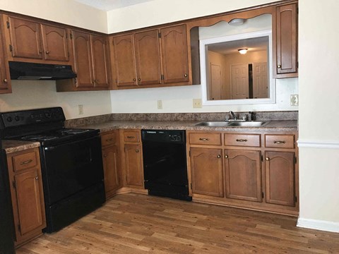 A kitchen with wooden cabinets and black appliances.