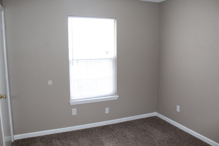 a room with a window and a carpet