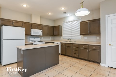 A kitchen with brown cabinets and a white refrigerator.
